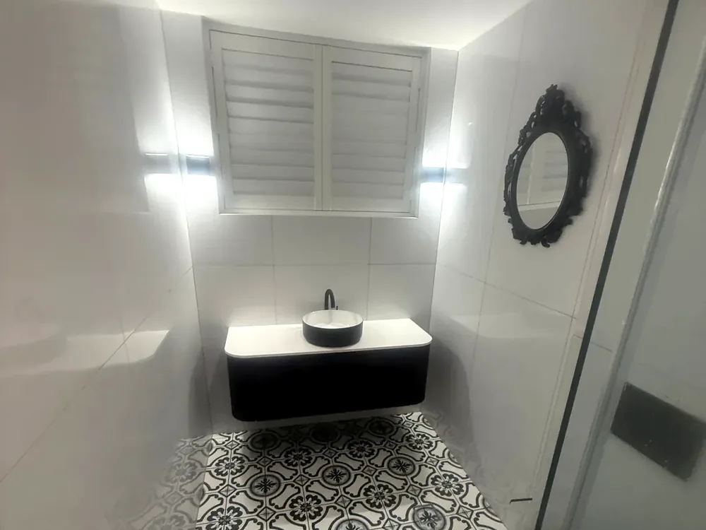 Bathroom renovation with black vanity and patterned floor tile